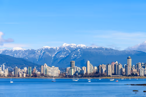 Vancouver skyline with mountains in the background, representing leadership and growth in a West Coast business environment