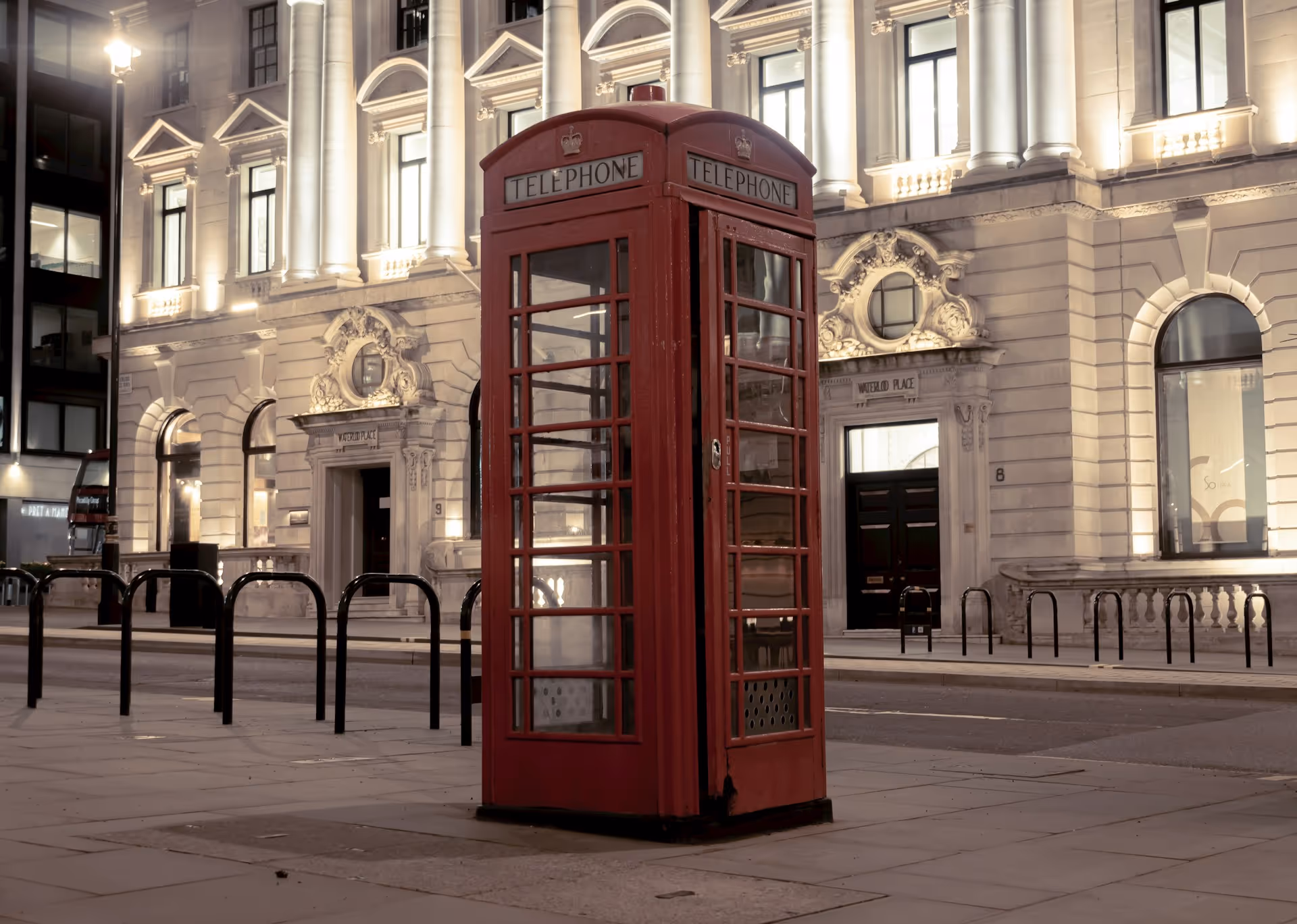 Iconic red telephone booth in front of a historic London building — representing tradition and leadership